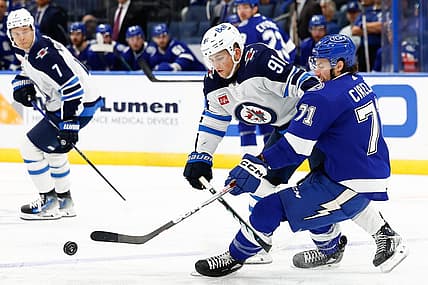 Nov 22, 2023; Tampa, Florida, USA; Winnipeg Jets center Cole Perfetti (91) and Tampa Bay Lightning center Anthony Cirelli (71) fight for the puck during the second period at Amalie Arena. Mandatory Credit: Douglas DeFelice-USA TODAY Sports