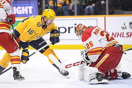 Nov 22, 2023; Nashville, Tennessee, USA; Calgary Flames goaltender Jacob Markstrom (25) blocks the shot of Nashville Predators center Colton Sissons (10) during the first period at Bridgestone Arena. Mandatory Credit: Steve Roberts-USA TODAY Sports