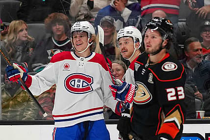 Nov 22, 2023; Anaheim, California, USA; Montreal Canadiens defenseman Kaiden Guhle (21) and left wing Michael Pezzetta (55) celebrate after a goal as Anaheim Ducks center Mason McTavish (23) reacts in the first period at Honda Center. Mandatory Credit: Kirby Lee-USA TODAY Sports