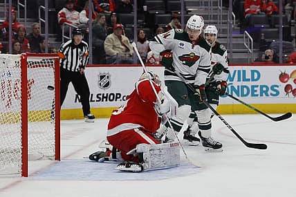 Nov 26, 2023; Detroit, Michigan, USA;  Minnesota Wild center Joel Eriksson Ek (14) scores a goal on Detroit Red Wings goaltender Alex Lyon (34) in the first period at Little Caesars Arena. Mandatory Credit: Rick Osentoski-USA TODAY Sports