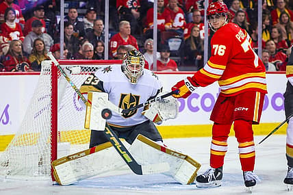Nov 27, 2023; Calgary, Alberta, CAN; Vegas Golden Knights goaltender Adin Hill (33) guards his net as Calgary Flames center Martin Pospisil (76) tries to redirect the puck during the second period at Scotiabank Saddledome. Mandatory Credit: Sergei Belski-USA TODAY Sports