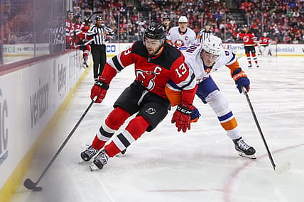 Nov 28, 2023; Newark, New Jersey, USA; New Jersey Devils center Nico Hischier (13) skates with the puck while being defended by New York Islanders defenseman Noah Dobson (8) during the second period at Prudential Center. Mandatory Credit: Ed Mulholland-USA TODAY Sports