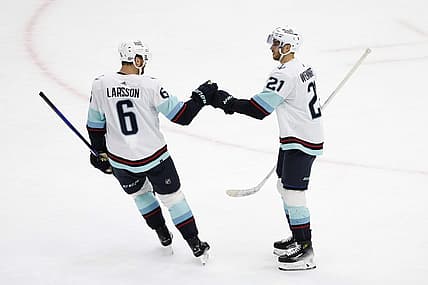 Nov 28, 2023; Chicago, Illinois, USA; Seattle Kraken center Alex Wennberg (21) celebrates with defenseman Adam Larsson (6) after scoring against the Chicago Blackhawks during the first period at United Center. Mandatory Credit: Kamil Krzaczynski-USA TODAY Sports