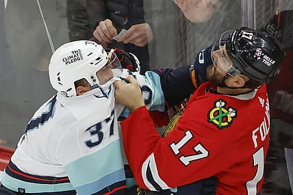 Nov 28, 2023; Chicago, Illinois, USA; Seattle Kraken center Yanni Gourde (37) fights with Chicago Blackhawks left wing Nick Foligno (17) during the second period at United Center. Mandatory Credit: Kamil Krzaczynski-USA TODAY Sports