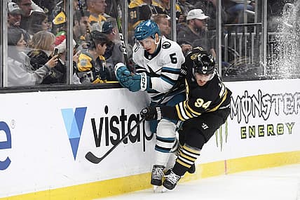 Nov 30, 2023; Boston, Massachusetts, USA; Boston Bruins center Jakub Lauko (94) checks San Jose Sharks defenseman Matt Benning (5) along the boards during the first period at TD Garden. Mandatory Credit: Bob DeChiara-USA TODAY Sports
