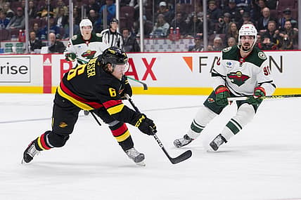 Mar 2, 2023; Vancouver, British Columbia, CAN; Minnesota Wild forward Marcus Johansson (90) watches as Vancouver Canucks forward Brock Boeser (6) shoots in the third period at Rogers Arena. Wild won 2-1. Mandatory Credit: Bob Frid-USA TODAY Sports