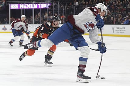 Dec 2, 2023; Anaheim, California, USA; Colorado Avalanche right wing Mikko Rantanen (96) attempts a shot as Anaheim Ducks defensemen Urho Vaakanainen (5) pursues during the first period at Honda Center. Mandatory Credit: Yannick Peterhans-USA TODAY Sports