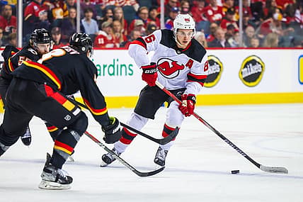 Dec 9, 2023; Calgary, Alberta, CAN; New Jersey Devils center Jack Hughes (86) controls the puck against the Calgary Flames during the first period at Scotiabank Saddledome. Mandatory Credit: Sergei Belski-USA TODAY Sports