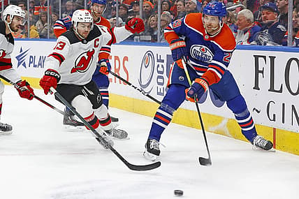 Dec 10, 2023; Edmonton, Alberta, CAN; Edmonton Oilers forward Leon Draisaitl (29) makes pass in front of to f New Jersey Devils forward Nico Hischier (13) during the first period at Rogers Place. Mandatory Credit: Perry Nelson-USA TODAY Sports