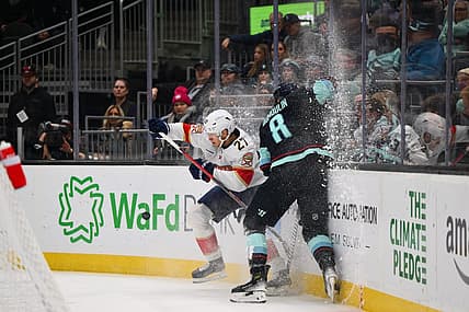 Dec 12, 2023; Seattle, Washington, USA; Florida Panthers center Eetu Luostarinen (27) checks Seattle Kraken defenseman Brian Dumoulin (8) into the wall during the first period at Climate Pledge Arena. Mandatory Credit: Steven Bisig-USA TODAY Sports.