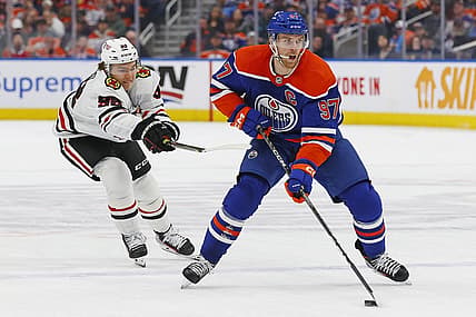 Dec 12, 2023; Edmonton, Alberta, CAN; Chicago Blackhawks forward Connor Bedard (98) tries to knock the puck away from Edmonton Oilers forward Connor McDavid (97) during the first period at Rogers Place. Mandatory Credit: Perry Nelson-USA TODAY Sports