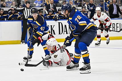 Dec 14, 2023; St. Louis, Missouri, USA;  Ottawa Senators left wing Brady Tkachuk (7) falls to the ice as St. Louis Blues defenseman Torey Krug (47) and defenseman Justin Faulk (72) defend during the first period at Enterprise Center. Mandatory Credit: Jeff Curry-USA TODAY Sports