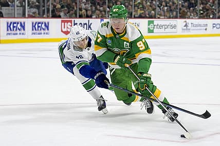 Dec 16, 2023; Saint Paul, Minnesota, USA;  Minnesota Wild forward Kirill Kaprizov (97) controls the puck as Vancouver Canucks forward Elias Pettersson (40) defends during overtime at Xcel Energy Center. Mandatory Credit: Nick Wosika-USA TODAY Sports