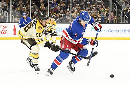 Dec 16, 2023; Boston, Massachusetts, USA;  Boston Bruins right wing David Pastrnak (88) and New York Rangers defenseman Braden Schneider (4) battle for the puck during the first period at TD Garden. Mandatory Credit: Bob DeChiara-USA TODAY Sports