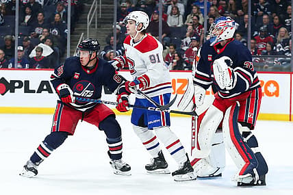 Dec 18, 2023; Winnipeg, Manitoba, CAN; Montreal Canadiens forward Sean Monohan (91) jostles for position with Winnipeg Jets defenseman Nate Schmidt (88) in front of Winnipeg Jets goalie Connor Hellebuyck (37) during the first period at Canada Life Centre. Mandatory Credit: Terrence Lee-USA TODAY Sports