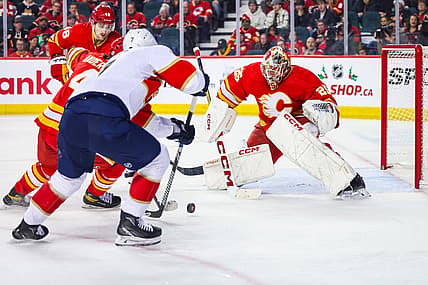 Dec 18, 2023; Calgary, Alberta, CAN; Calgary Flames goaltender Jacob Markstrom (25) makes a save against Florida Panthers defenseman Dmitry Kulikov (7) during the second period at Scotiabank Saddledome. Mandatory Credit: Sergei Belski-USA TODAY Sports