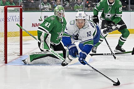 Dec 21, 2023; Dallas, Texas, USA; Vancouver Canucks center Teddy Blueger (53) is tripped up in front of Dallas Stars goaltender Scott Wedgewood (41) as he tires to control the puck during the first period at the American Airlines Center. Mandatory Credit: Jerome Miron-USA TODAY Sports