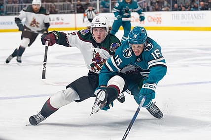 Dec 21, 2023; San Jose, California, USA; Arizona Coyotes center Logan Cooley (92) and San Jose Sharks center Jack Studnicka (16) collides during the first period at SAP Center at San Jose. Mandatory Credit: Stan Szeto-USA TODAY Sports