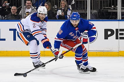 Dec 22, 2023; New York, New York, USA;  Edmonton Oilers defenseman Evan Bouchard (2) defends against New York Rangers center Vincent Trocheck (16) during the second period at Madison Square Garden. Mandatory Credit: Dennis Schneidler-USA TODAY Sports