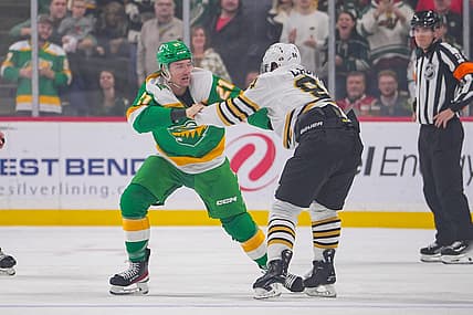 Dec 23, 2023; Saint Paul, Minnesota, USA; Minnesota Wild right wing Brandon Duhaime (21) and Boston Bruins center Jakub Lauko (94) fight  in the first period at Xcel Energy Center. Mandatory Credit: Brad Rempel-USA TODAY Sports