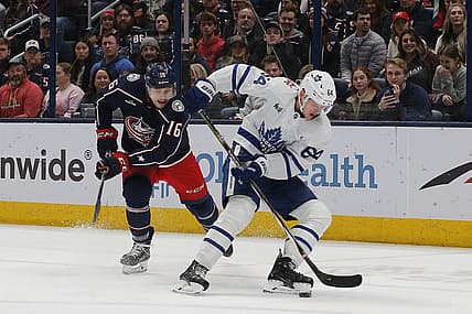 Dec 23, 2023; Columbus, Ohio, USA; Toronto Maple Leafs center David Kampf (64) picks up a loose puck as Columbus Blue Jackets center Brendan Gaunce (16) trails the play during the first period at Nationwide Arena. Mandatory Credit: Russell LaBounty-USA TODAY Sports
