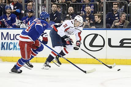 Dec 27, 2023; New York, New York, USA; Washington Capitals center Aliaksei Protas (21) skates past New York Rangers defenseman Braden Schneider (4) in the first period at Madison Square Garden. Mandatory Credit: Wendell Cruz-USA TODAY Sports