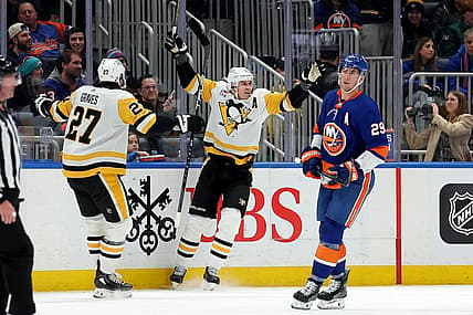 Dec 27, 2023; Elmont, New York, USA; Pittsburgh Penguins center Evgeni Malkin (71) celebrates his goal against the New York Islanders with defenseman Ryan Graves (27) in front of Islanders center Brock Nelson (29) during the second period at UBS Arena. Mandatory Credit: Brad Penner-USA TODAY Sports