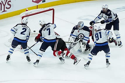 Dec 27, 2023; Chicago, Illinois, USA; Chicago Blackhawks center Connor Bedard (98) scores a goal on Winnipeg Jets goaltender Connor Hellebuyck (37) during the first period at United Center. Mandatory Credit: David Banks-USA TODAY Sports