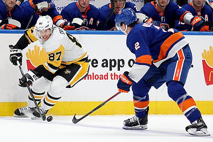Dec 27, 2023; Elmont, New York, USA; Pittsburgh Penguins center Sidney Crosby (87) controls the puck against New York Islanders defenseman Mike Reilly (2) during the third period at UBS Arena. Mandatory Credit: Brad Penner-USA TODAY Sports