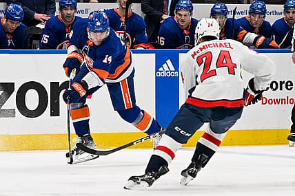 Dec 29, 2023; Elmont, New York, USA; New York Islanders center Bo Horvat (14) keeps the puck in the zone defended by Washington Capitals center Connor McMichael (24) during the second period at UBS Arena. Mandatory Credit: Dennis Schneidler-USA TODAY Sports