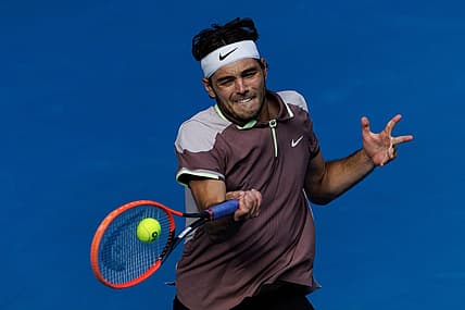 Jan 23, 2024; Melbourne, Victoria, Australia;  Taylor Fritz of the United States in action against Novak Djokovic of Serbia in the quarter final of the men s singles. Mandatory Credit: Mike Frey-USA TODAY Sports
