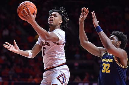 Feb 13, 2024; Champaign, Illinois, USA; Illinois Fighting Illini guard Terrence Shannon Jr. (0) drives past Michigan Wolverines forward Tarris Reed Jr. (32) on his way to the basket during the first half at State Farm Center. Mandatory Credit: Ron Johnson-USA TODAY Sports