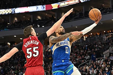 Feb 13, 2024; Milwaukee, Wisconsin, USA; Milwaukee Bucks guard Damian Lillard (0) drives to the basket against Miami Heat forward Duncan Robinson (55) in the first half at Fiserv Forum. Mandatory Credit: Michael McLoone-USA TODAY Sports