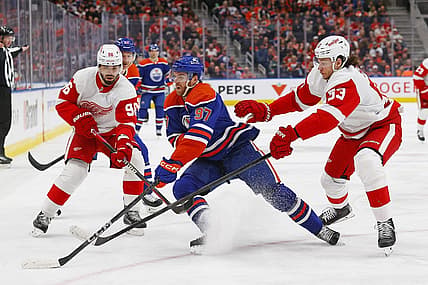 Feb 13, 2024; Edmonton, Alberta, CAN; Edmonton Oilers forward Connor McDavid (97) protects the puck from Detroit Red Wings defensemen Moritz Seider (53) and defensemen Jake Walman (96) at Rogers Place. Mandatory Credit: Perry Nelson-USA TODAY Sports