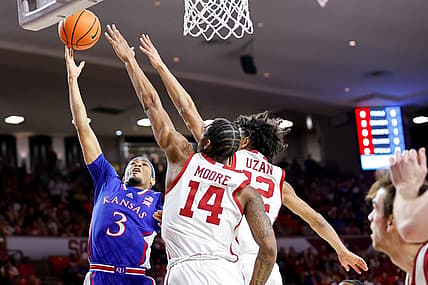 Kansas guard Dajuan Harris Jr. (3) lays up the ball past Oklahoma guard Milos Uzan (12) and Oklahoma forward Jalon Moore (14) in the first half during an NCAA basketball game between The University of Oklahoma (OU) and The University of Kansas (KU), at the Lloyd Noble Center in Norman Okla., on Saturday, Feb. 17, 2024.