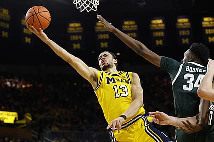 Feb 17, 2024; Ann Arbor, Michigan, USA; Michigan Wolverines forward Olivier Nkamhoua (13) shoots on Michigan State Spartans forward Xavier Booker (34) in the first half  at Crisler Center. Mandatory Credit: Rick Osentoski-USA TODAY Sports