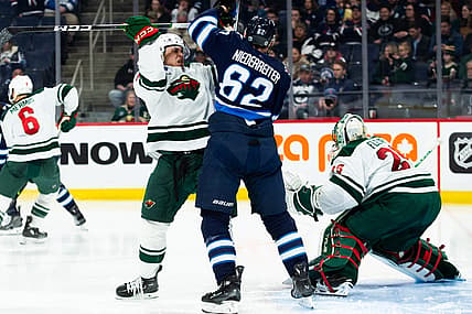 Feb 20, 2024; Winnipeg, Manitoba, CAN; Winnipeg Jets forward Nino Niederreiter (62) jostles for position with Minnesota Wild defenseman Alex Goligoski (33) during the second period at Canada Life Centre. Mandatory Credit: Terrence Lee-USA TODAY Sports