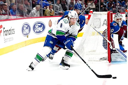 Feb 20, 2024; Denver, Colorado, USA; Vancouver Canucks right wing Brock Boeser (6) skates past Colorado Avalanche defenseman Devon Toews (7) in the third period at Ball Arena. Mandatory Credit: Ron Chenoy-USA TODAY Sports