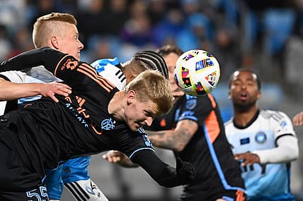 Feb 24, 2024; Charlotte, North Carolina, USA;  New York City midfielder Keaton Parks (55) heads the ball as Charlotte FC Junior Urso (30) defends in the first half at Bank of America Stadium. Mandatory Credit: Bob Donnan-USA TODAY Sports