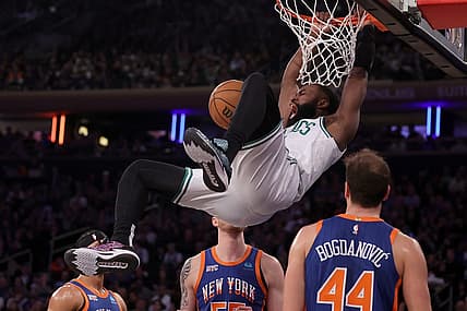 Feb 24, 2024; New York, New York, USA; Boston Celtics guard Jaylen Brown (7) hangs on the rim after a dunk against New York Knicks guard Josh Hart (3) and center Isaiah Hartenstein (55) and forward Bojan Bogdanovic (44) during the second quarter at Madison Square Garden. Mandatory Credit: Brad Penner-USA TODAY Sports