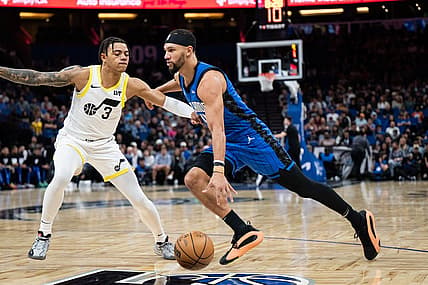 Feb 29, 2024; Orlando, Florida, USA; Orlando Magic guard Jalen Suggs (4) dribbles the ball against Utah Jazz guard Keyonte George (3) in the first quarter at Kia Center. Mandatory Credit: Jeremy Reper-USA TODAY Sports
