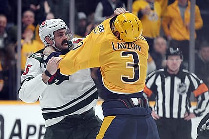 Feb 29, 2024; Nashville, Tennessee, USA; Minnesota Wild defenseman Jake Middleton (5) and Nashville Predators defenseman Jeremy Lauzon (3) exchange punches during a fight during the second period at Bridgestone Arena. Mandatory Credit: Christopher Hanewinckel-USA TODAY Sports