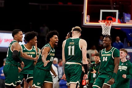 South Florida's Sam Hines Jr. (20) slaps Kasean Pryor (11) on the back as the team celebrates as the buzzer sounds after defeating Memphis 74-73 at FedExForum in Memphis, Tenn., on Thursday, January 18, 2024.