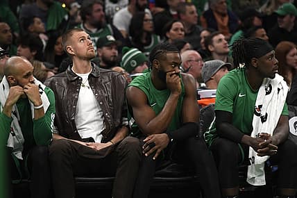 Jan 27, 2024; Boston, Massachusetts, USA;  Boston Celtics center Kristaps Porzingis (8) guard Jaylen Brown (7) and guard Jrue Holiday (4) on the bench during the second half against the LA Clippers at TD Garden. Mandatory Credit: Bob DeChiara-USA TODAY Sports