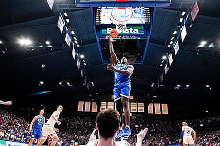 Feb 27, 2024; Lawrence, Kansas, USA; Brigham Young Cougars forward Fousseyni Traore (45) shoots as Kansas Jayhawks forward Parker Braun (23) falls below him during the second half at Allen Fieldhouse. Mandatory Credit: Denny Medley-USA TODAY Sports