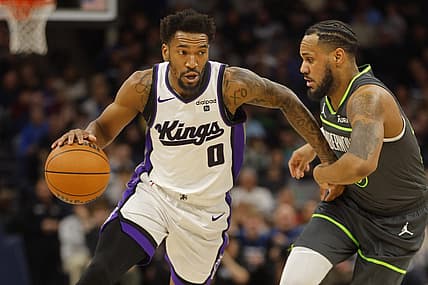 Mar 1, 2024; Minneapolis, Minnesota, USA; Sacramento Kings guard Malik Monk (0) works around Minnesota Timberwolves guard Monte Morris (23) in the first quarter at Target Center. Mandatory Credit: Bruce Kluckhohn-USA TODAY Sports