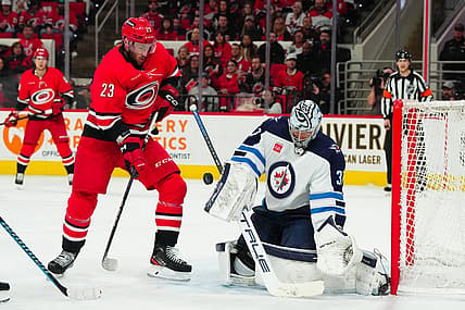 Mar 2, 2024; Raleigh, North Carolina, USA; Winnipeg Jets goaltender Connor Hellebuyck (37) makes a save in front of Carolina Hurricanes right wing Stefan Noesen (23) during the first period at PNC Arena. Mandatory Credit: James Guillory-USA TODAY Sports
