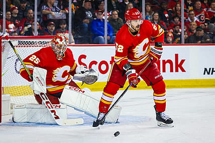 Mar 4, 2024; Calgary, Alberta, CAN; Calgary Flames defenseman MacKenzie Weegar (52) controls the puck in front of Calgary Flames goaltender Jacob Markstrom (25) during the first period against the Seattle Kraken at Scotiabank Saddledome. Mandatory Credit: Sergei Belski-USA TODAY Sports