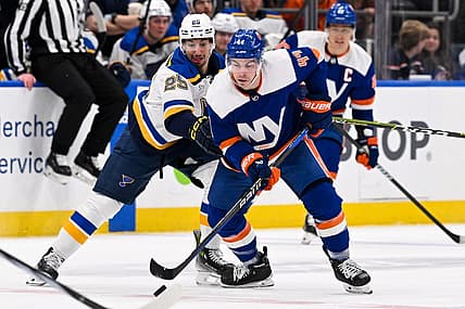 Mar 5, 2024; Elmont, New York, USA;  New York Islanders center Jean-Gabriel Pageau (44) and St. Louis Blues center Jordan Kyrou (25) battle for a loose puck during the first period at UBS Arena. Mandatory Credit: Dennis Schneidler-USA TODAY Sports