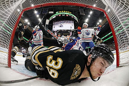 Mar 5, 2024; Boston, Massachusetts, USA; Boston Bruins center Morgan Geekie (39) is dumped into the Edmonton Oilers net during the second period at TD Garden. Mandatory Credit: Winslow Townson-USA TODAY Sports